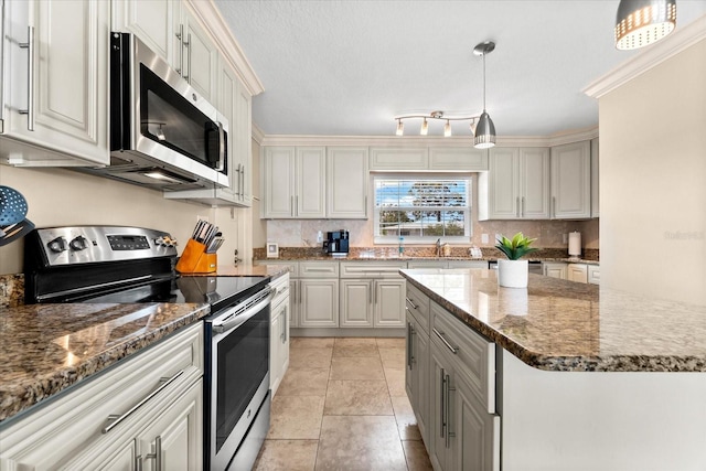 1723 Laramie St, Sarasota, FL 34231 - kitchen featuring appliances with stainless steel finishes, tasteful backsplash, gray cabinetry, dark stone counters, and decorative light fixtures