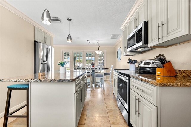 1723 Laramie St, Sarasota, FL 34231 - kitchen featuring appliances with stainless steel finishes, a kitchen island, crown molding, stone counters, and a breakfast bar area