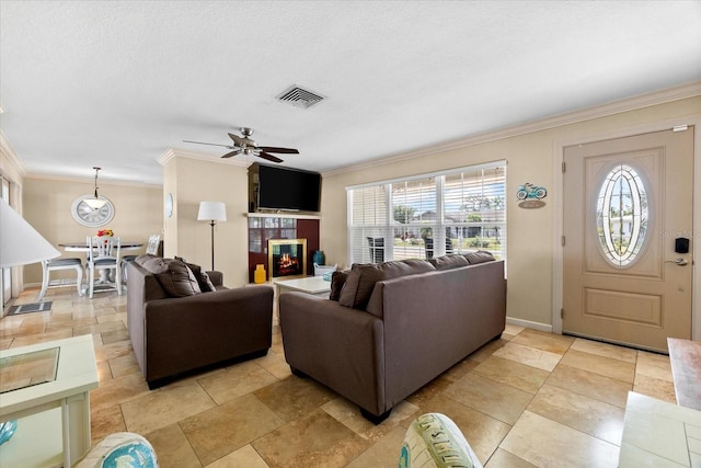 1723 Laramie St, Sarasota, FL 34231 - living area featuring crown molding, plenty of natural light, a ceiling fan, and a glass covered fireplace