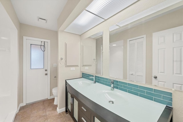 408 Fletcher St, Port Charlotte, FL 33954 - bathroom with toilet, a closet, double vanity, backsplash, and tile patterned flooring
