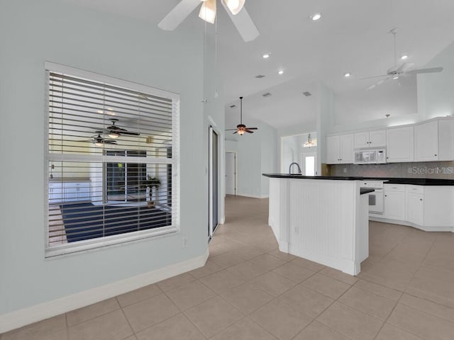 3616 SE 8th Pl, Cape Coral, FL 33904 - kitchen with a ceiling fan, white appliances, dark countertops, light tile patterned flooring, and high vaulted ceiling