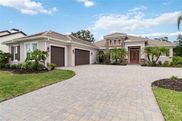 1015 143rd St NE, Bradenton, FL 34212 - prairie-style house featuring stucco siding, decorative driveway, a tiled roof, and an attached garage