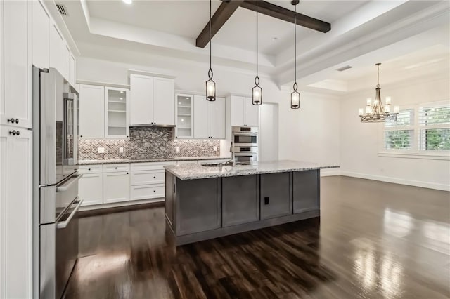 1015 143rd St NE, Bradenton, FL 34212 - kitchen with stainless steel appliances, a raised ceiling, dark wood-style floors, tasteful backsplash, and white cabinetry