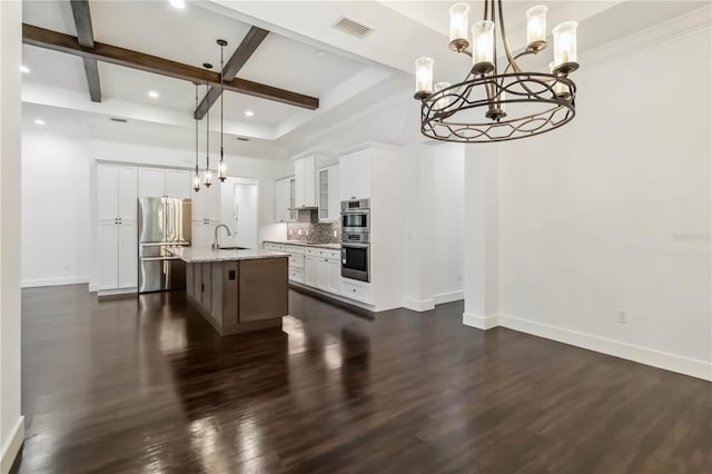 1015 143rd St NE, Bradenton, FL 34212 - kitchen with stainless steel appliances, a chandelier, baseboards, beam ceiling, and white cabinets