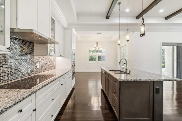 1015 143rd St NE, Bradenton, FL 34212 - kitchen with a sink, wall chimney range hood, black electric cooktop, decorative backsplash, and a kitchen island with sink
