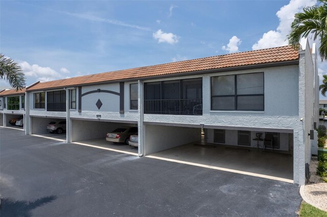 4210 SE 20th Pl Unit A8, Cape Coral, FL 33904 - rear view of house with a tile roof, stucco siding, and covered parking