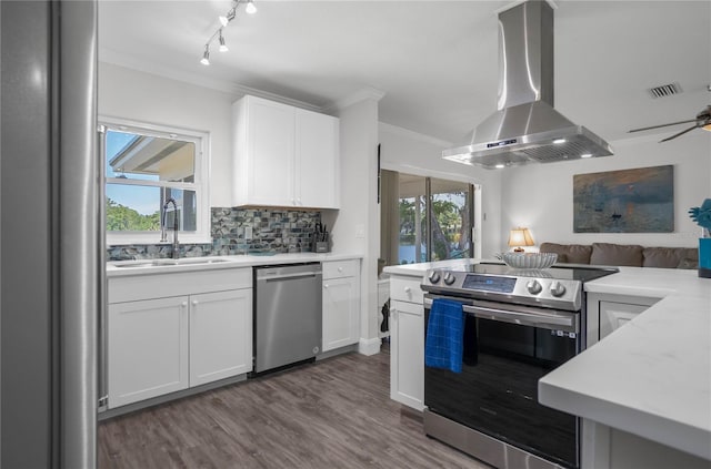 3861 N Ringdove Pt, Crystal River, FL 34428 - kitchen featuring stainless steel appliances, wall chimney range hood, a sink, ornamental molding, and open floor plan
