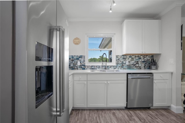 3861 N Ringdove Pt, Crystal River, FL 34428 - kitchen with stainless steel appliances, a sink, white cabinetry, wood finished floors, and ornamental molding