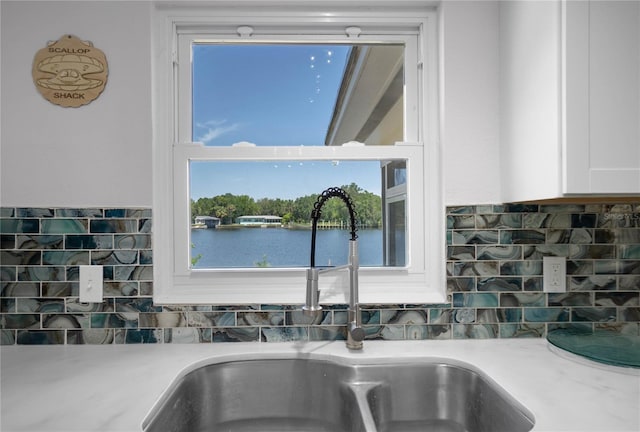 3861 N Ringdove Pt, Crystal River, FL 34428 - kitchen view of a sink, white cabinetry, tasteful backsplash, and light countertops