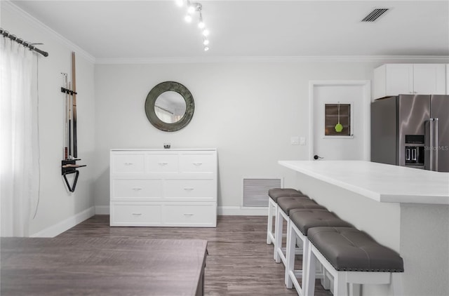 3861 N Ringdove Pt, Crystal River, FL 34428 - kitchen with high quality fridge, baseboards, dark wood-type flooring, white cabinets, and ornamental molding