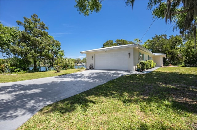 3861 N Ringdove Pt, Crystal River, FL 34428 - view of front of home featuring a front yard, stucco siding, a garage, driveway, and a water view