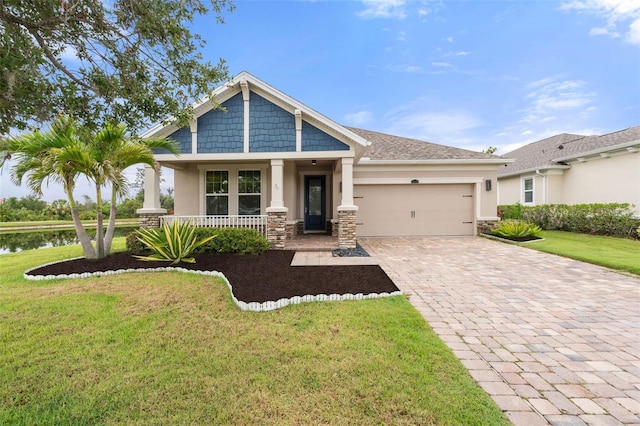 5240 Bentgrass Way, Bradenton, FL 34211 - craftsman inspired home featuring stucco siding, decorative driveway, an attached garage, stone siding, and a front lawn