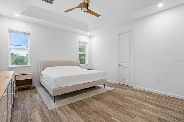5240 Bentgrass Way, Bradenton, FL 34211 - bedroom with light wood finished floors, a raised ceiling, baseboards, recessed lighting, and a ceiling fan