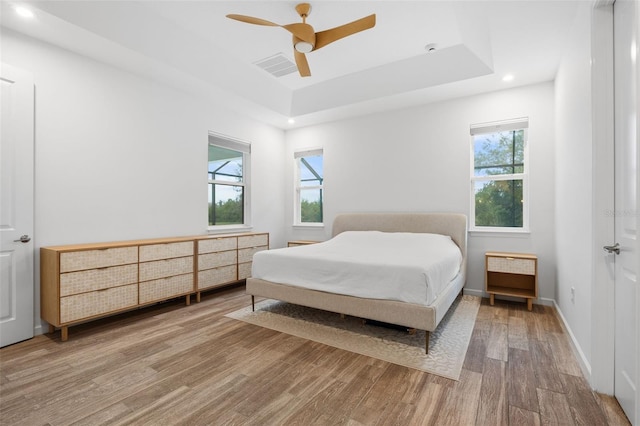 5240 Bentgrass Way, Bradenton, FL 34211 - bedroom featuring wood finished floors, a raised ceiling, recessed lighting, a ceiling fan, and baseboards