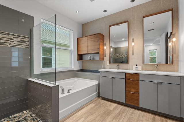 5240 Bentgrass Way, Bradenton, FL 34211 - bathroom featuring a walk in shower, double vanity, a bath, wood finished floors, and tasteful backsplash