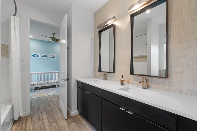 5240 Bentgrass Way, Bradenton, FL 34211 - ensuite bathroom featuring wood finished floors, double vanity, decorative backsplash, shower / bath combo, and ceiling fan