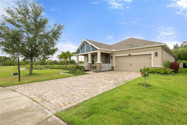 5240 Bentgrass Way, Bradenton, FL 34211 - craftsman-style home with covered porch, decorative driveway, an attached garage, a front lawn, and stucco siding