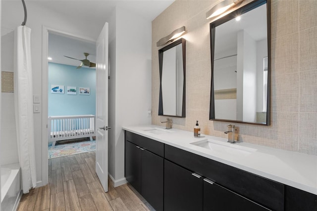 5240 Bentgrass Way, Bradenton, FL 34211 - ensuite bathroom featuring wood finished floors, double vanity, tasteful backsplash, ceiling fan, and shower / bath combo