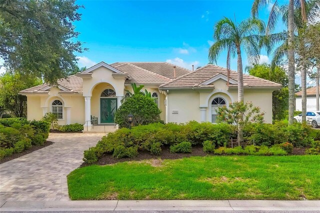 7214 Marlow Pl, University Park, FL 34201 - mediterranean / spanish home with stucco siding, decorative driveway, a front lawn, and a tile roof