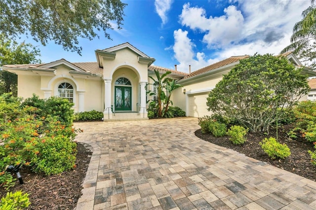 7214 Marlow Pl, University Park, FL 34201 - mediterranean / spanish-style house with an attached garage, decorative driveway, stucco siding, french doors, and a tile roof