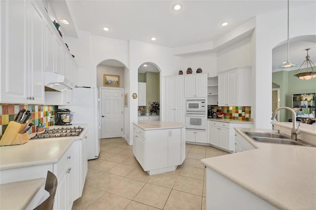 7214 Marlow Pl, University Park, FL 34201 - kitchen featuring white appliances, light tile patterned floors, arched walkways, tasteful backsplash, and recessed lighting