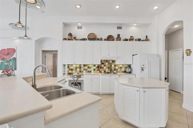 7214 Marlow Pl, University Park, FL 34201 - kitchen with white fridge with ice dispenser, an island with sink, arched walkways, gas stovetop, and under cabinet range hood