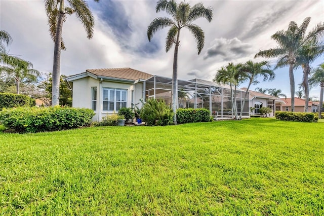 7214 Marlow Pl, University Park, FL 34201 - back of house featuring stucco siding, a lawn, a tiled roof, and a lanai