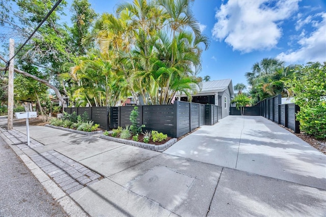 1919 Laurel St, Sarasota, FL 34236 - exterior space with a fenced front yard, concrete driveway, a gate, a metal roof, and stucco siding