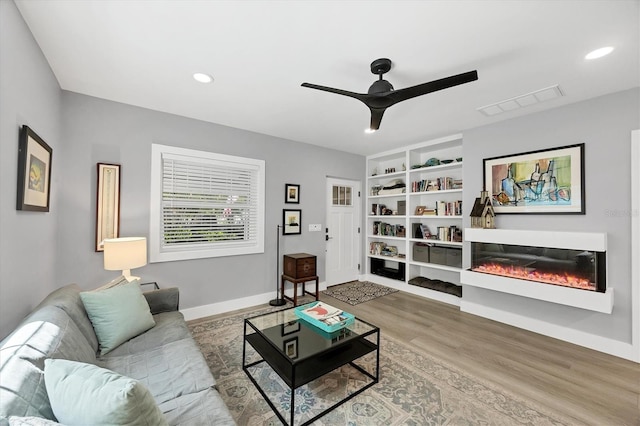 1919 Laurel St, Sarasota, FL 34236 - living area featuring ceiling fan, wood finished floors, built in shelves, recessed lighting, and a glass covered fireplace