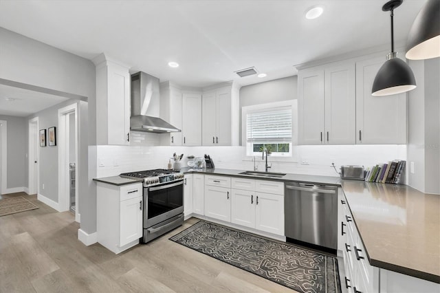 1919 Laurel St, Sarasota, FL 34236 - kitchen featuring wall chimney range hood, stainless steel appliances, light wood-style flooring, backsplash, and recessed lighting