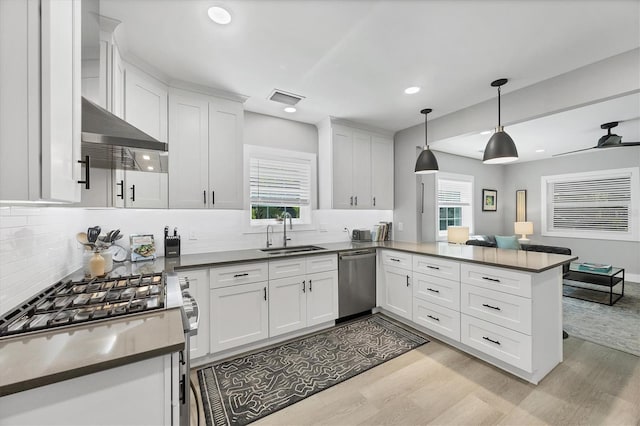 1919 Laurel St, Sarasota, FL 34236 - kitchen featuring stainless steel appliances, a peninsula, light wood-style floors, white cabinetry, and recessed lighting