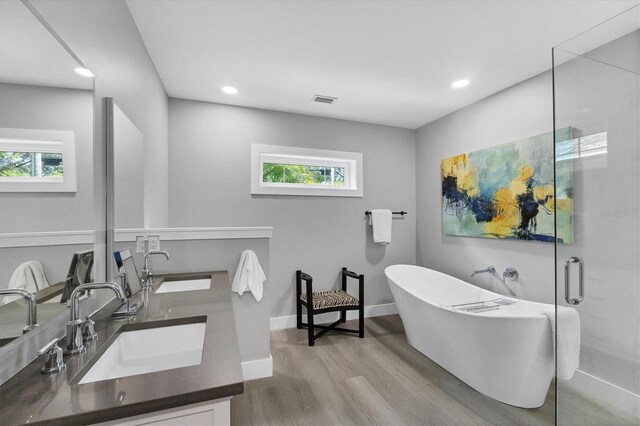 1919 Laurel St, Sarasota, FL 34236 - full bath featuring wood finished floors, double vanity, a freestanding bath, recessed lighting, and a stall shower