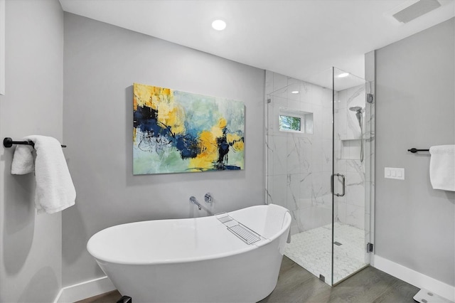 1919 Laurel St, Sarasota, FL 34236 - full bath featuring wood finished floors, a freestanding bath, a marble finish shower, and recessed lighting