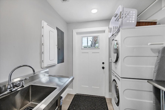 1919 Laurel St, Sarasota, FL 34236 - laundry room featuring stacked washer / drying machine, electric panel, and light wood-type flooring