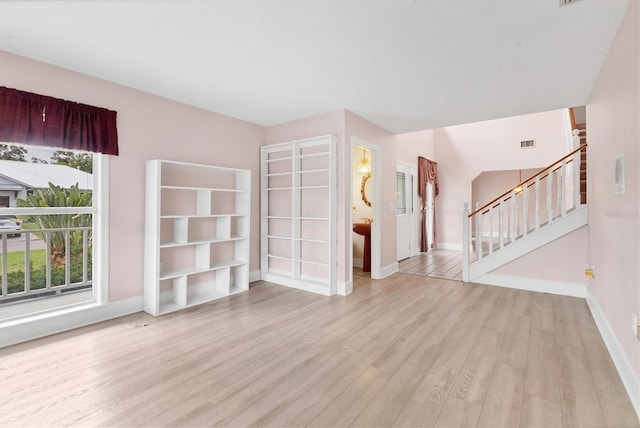 2002 8th St W, Palmetto, FL 34221 - unfurnished living room with wood finished floors, baseboards, and stairs