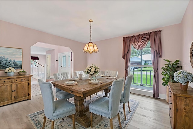 2002 8th St W, Palmetto, FL 34221 - dining area with light wood-style floors, arched walkways, a chandelier, and stairway