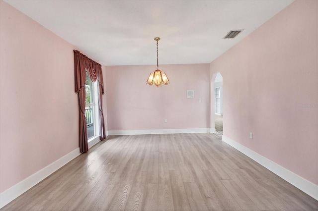 2002 8th St W, Palmetto, FL 34221 - empty room with arched walkways, light wood-style flooring, a chandelier, and baseboards