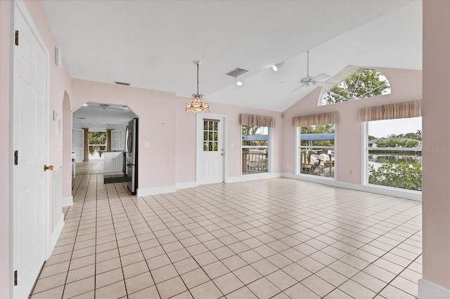 2002 8th St W, Palmetto, FL 34221 - unfurnished living room featuring light tile patterned floors, a ceiling fan, arched walkways, baseboards, and a water view