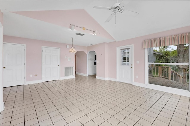 2002 8th St W, Palmetto, FL 34221 - unfurnished living room featuring a ceiling fan, lofted ceiling, arched walkways, light tile patterned flooring, and rail lighting