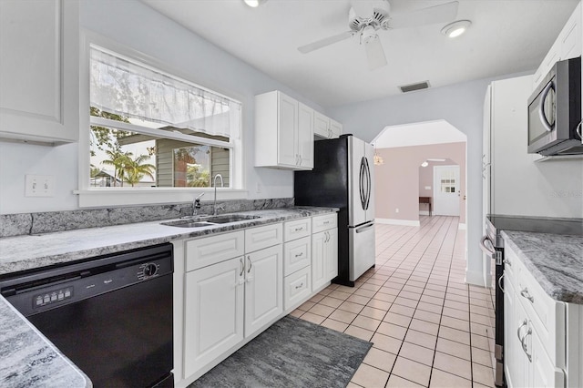2002 8th St W, Palmetto, FL 34221 - kitchen featuring stainless steel appliances, a sink, a ceiling fan, white cabinetry, and arched walkways