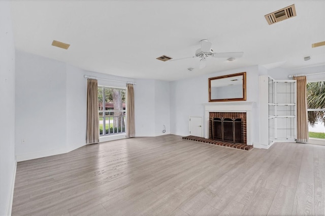 2002 8th St W, Palmetto, FL 34221 - unfurnished living room featuring wood finished floors, a ceiling fan, a brick fireplace, and baseboards