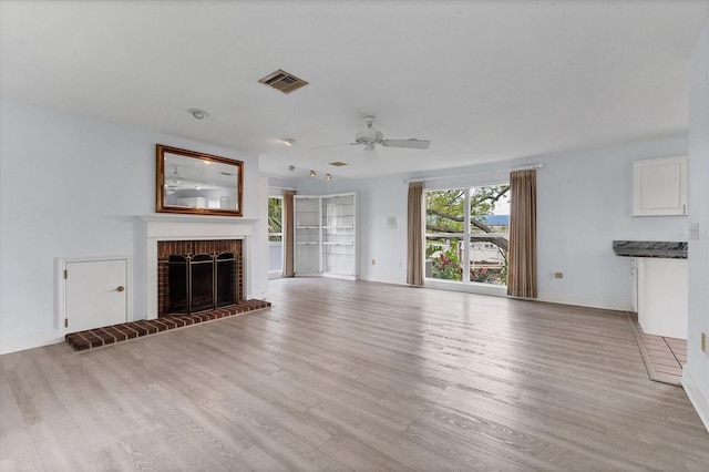 2002 8th St W, Palmetto, FL 34221 - unfurnished living room featuring light wood finished floors, ceiling fan, a fireplace, and baseboards
