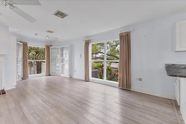 2002 8th St W, Palmetto, FL 34221 - unfurnished living room featuring light wood-type flooring, ceiling fan, and baseboards