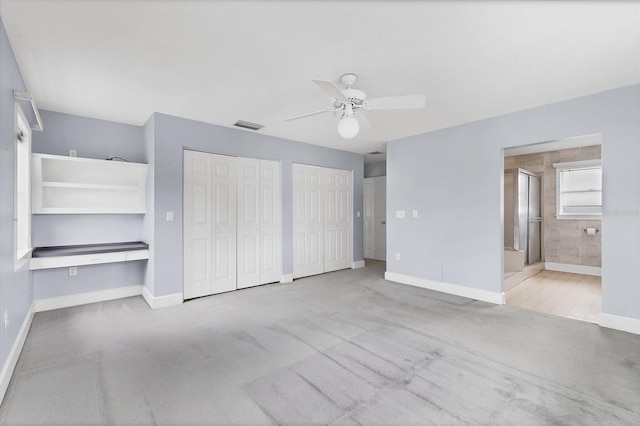 2002 8th St W, Palmetto, FL 34221 - unfurnished bedroom featuring multiple closets, baseboards, carpet, and a ceiling fan
