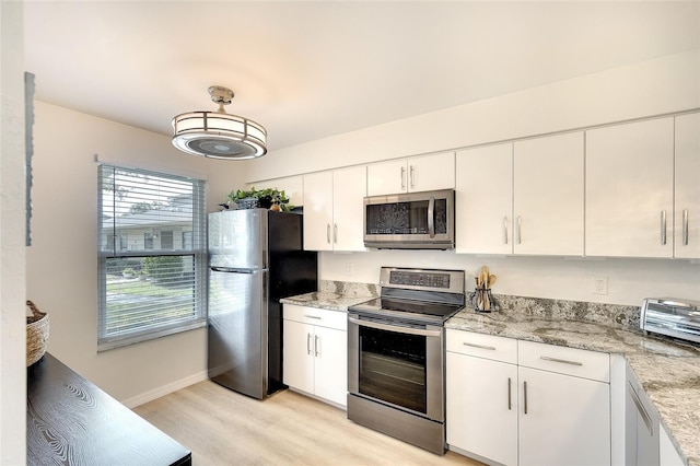 6024 28th St W, Bradenton, FL 34207 - kitchen with stainless steel appliances, light wood-style flooring, white cabinetry, and light stone countertops