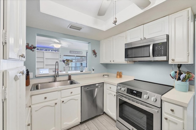 2740 Orchid Oaks Dr Unit 304, Sarasota, FL 34239 - kitchen with appliances with stainless steel finishes, a sink, ceiling fan, white cabinetry, and light countertops