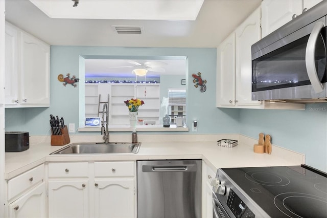 2740 Orchid Oaks Dr Unit 304, Sarasota, FL 34239 - kitchen featuring stainless steel appliances, a sink, white cabinetry, and light countertops