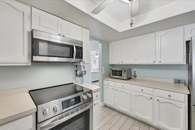 2740 Orchid Oaks Dr Unit 304, Sarasota, FL 34239 - kitchen featuring appliances with stainless steel finishes, a ceiling fan, white cabinets, light countertops, and light wood-style floors