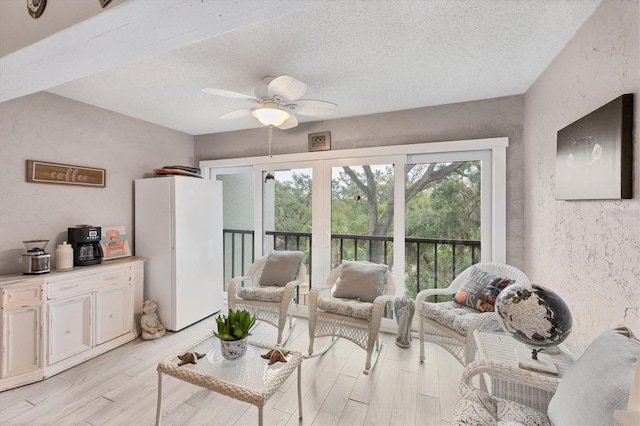 2740 Orchid Oaks Dr Unit 304, Sarasota, FL 34239 - living room with a ceiling fan, a textured ceiling, light wood-type flooring, and a textured wall