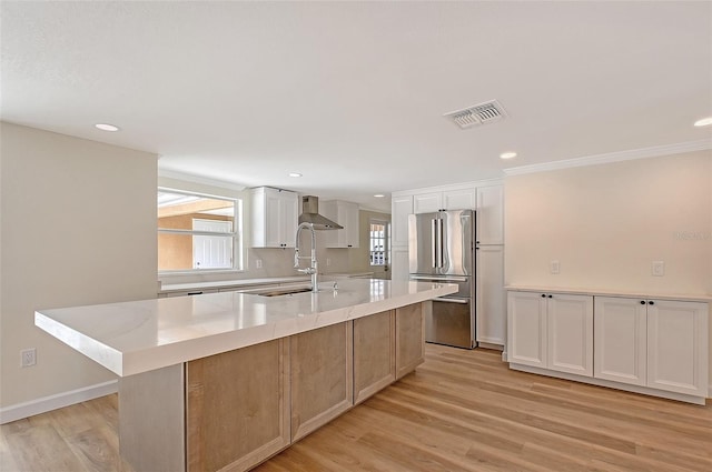 1203 Lyric Ln, Sarasota, FL 34242 - kitchen with high end fridge, a kitchen island with sink, white cabinetry, light wood finished floors, and recessed lighting